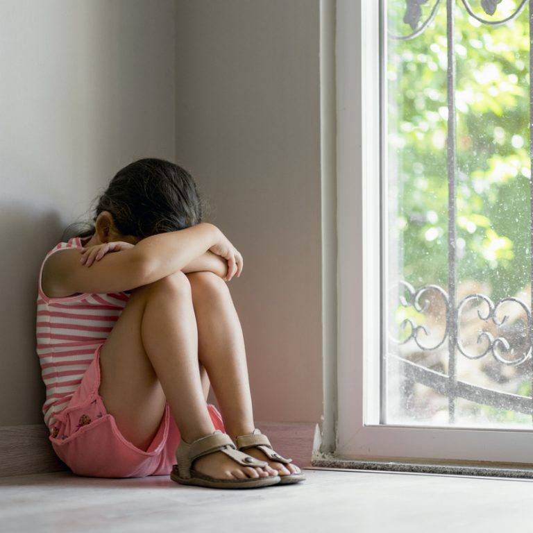 Offended little girl sitting on the floor