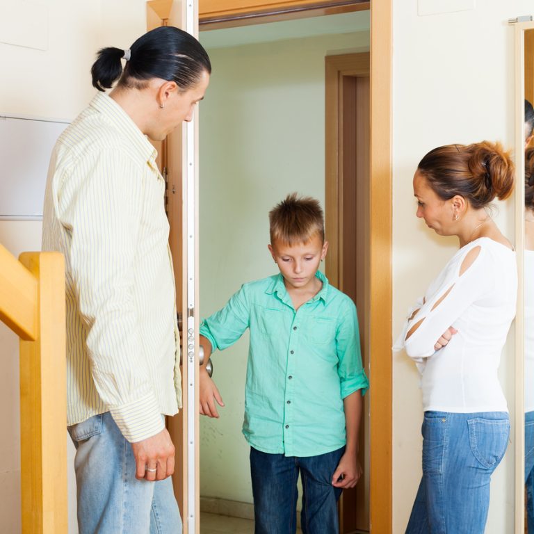 Parents meeting with scold of  son in doorway at home