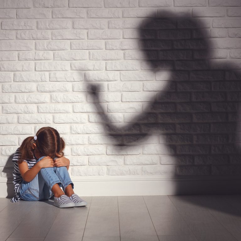 domestic violence. angry mother scolds   frightened daughter sitting on floor